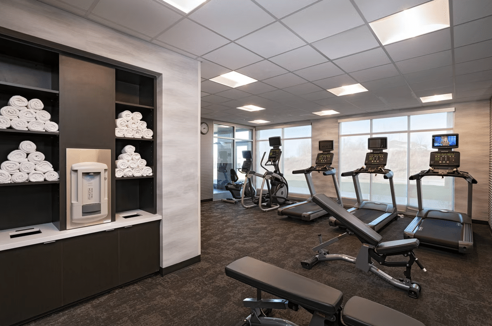 hotel fitness room with towels and shades